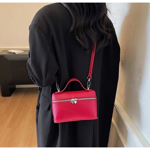 Détail du mini sac rouge en cuir grainé avec une fermeture éclair en cœur argenté