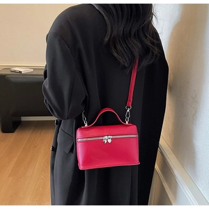 Détail d'un sac boîte en cuir rouge texturé avec tirettes de fermeture en forme de cœur