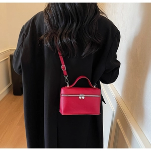 Détail du sac rouge avec fermetures éclair en forme de cœur et texture grainée fine