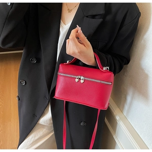 Détail du sac bandoulière en cuir grainé rouge avec fermoir métallique en forme de cœur