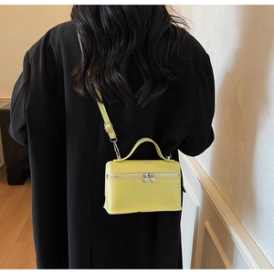 Détail du sac bandoulière jaune vif avec fermetures éclair argentées en forme de cœur