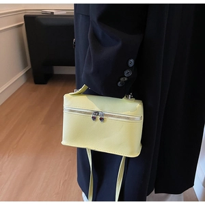 Détail du sac boîte jaune avec texture litchi et fermeture éclair argentée en cœur