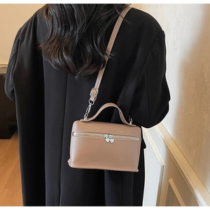 Détails du sac à bandoulière beige avec fermetures cœur et texture cuir grainé
