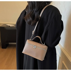 Détail de la texture cuir abricot et fermeture éclair en forme de cœur sur le sac carré