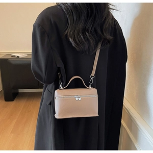 Detail of lychee pattern leather handbag with heart-shaped zipper and crossbody strap