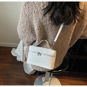 Vue détaillée d'un mannequin portant un sac bandoulière blanc en cuir grainé