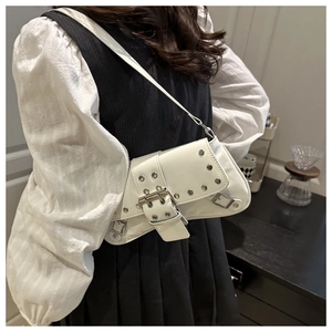 Detail of white patent leather shoulder bag with silver studs and metal buckle closure