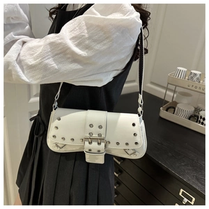 Détail du sac bandoulière en cuir verni blanc avec clous argentés et boucle en métal
