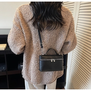 Détail de la fermeture éclair argentée en forme de cœur sur le sac en cuir noir