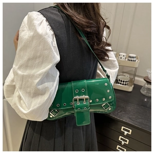 Detail of green patent leather underarm bag with silver rivets and metal buckles