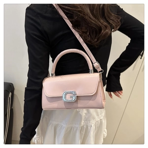 Dettaglio della borsa in pelle verniciata rosa chiaro con fibbia in metallo a G