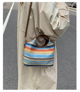 Détail d'un sac cabas tissé aux rayures colorées avec une bandoulière en cuir marron