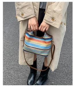 Détails d'un sac bandoulière tissé coloré avec poignées en cuir et finitions dorées