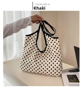 Detail of khaki polka dot canvas tote bag with dual straps in a lifestyle setting
