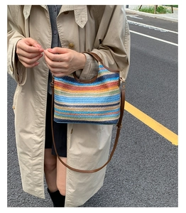 Détail du sac tissé à rayures colorées avec poignées et bandoulière en cuir marron