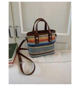 Macro detail of multi-color woven straw tote with premium leather handles and silver hardware