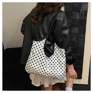 Polka dot canvas tote bag detail on shoulder with minimalist black and white print