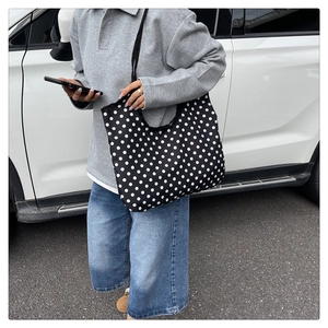 Detailed view of large polka dot canvas tote bag worn over the shoulder for daily use
