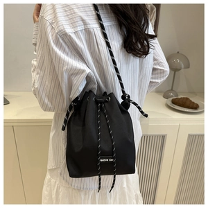 Détail du sac seau en nylon noir avec cordons tissés et finitions logo épurées