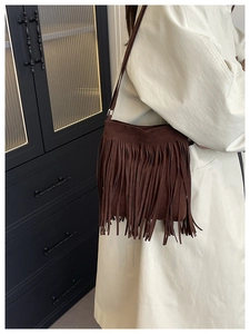 Detail shot of brown suede tassel shoulder bag showing the bohemian fringe texture