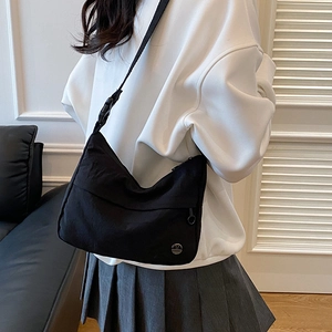 Minimalist black nylon crossbody bag with adjustable strap and waterproof canvas material