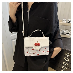 Detail of white PU crossbody bag with 3D cherry pendants and floral print pattern