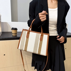 Fashionable canvas tote bag with brown leather trim and vertical stripes for women