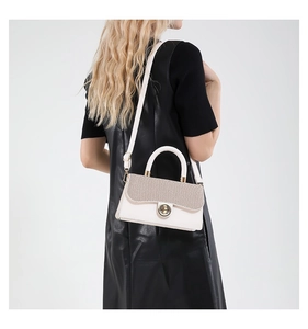 Détail du sac bandoulière en cuir ivoire avec rabat tissé et fermoir rotatif en métal