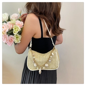 Detail of straw woven shoulder bag with pearl sea shell chain and white leather strap