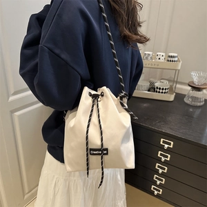 Sac seau chic en toile blanc cassé avec cordon et bandoulière tissée pour femmes