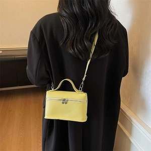 Bright yellow leather box crossbody bag with unique silver heart-shaped zipper pulls