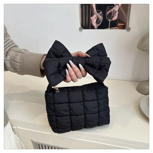 Dettaglio della borsa trapuntata nera con un design unico a fiocco grande sul manico largo