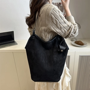 Large black faux suede tote bag for women with leather straps in a casual office setting