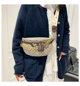 Detailed view of monogram chest bag with chunky gold chain and horse-bit charm