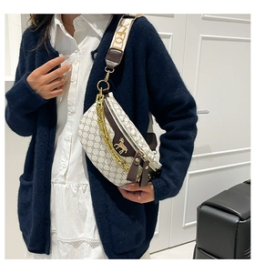 Close-up of white monogram chest bag featuring gold horse logo and thick chain detail
