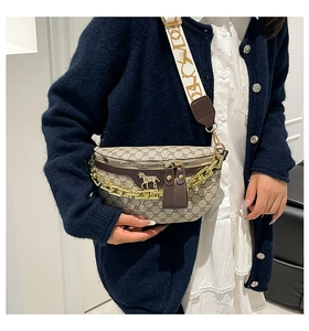 Detail of half-moon crossbody bag featuring jacquard logo pattern and gold chain