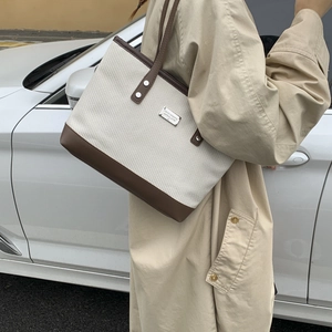Minimalist canvas and leather patchwork tote bag for women shown in an outdoor lifestyle setting