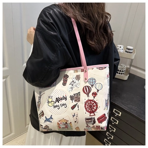 Dettaglio della borsa tote con graffiti di orsi, motivi di viaggio e manici rosa