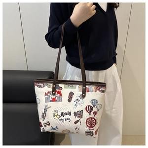 Détail du sac cabas blanc à graffitis avec illustrations et anses en cuir marron