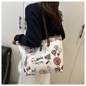 Dettaglio di una grande borsa tote bianca con scarabocchi di viaggio e manici in pelle