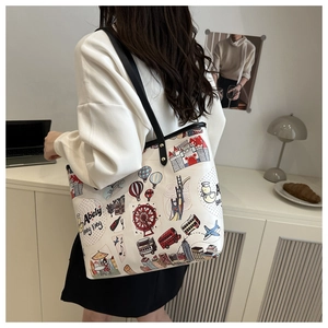 Détail du sac cabas blanc avec des illustrations de voyage colorées sur l'épaule