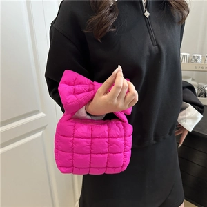 Magenta quilted puffer handbag with oversized bow detail and soft square design