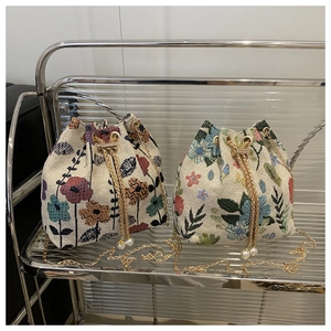 Detailed view of vintage ethnic bucket bags with floral embroidery and pearl drawstring
