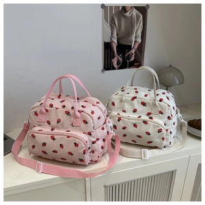 Details van roze en beige corduroy draagtassen met aardbeienprint en draagriemen