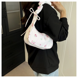 Detail of floral canvas bag with adjustable bow shoulder strap and rose prints