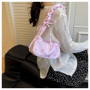 Detail of floral canvas shoulder bag with ruffled strap and ribbon bow decoration