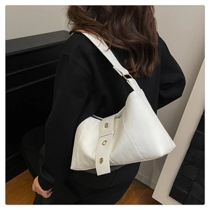 Detailed back view of a white minimalist shoulder bag featuring golden metal ring accents
