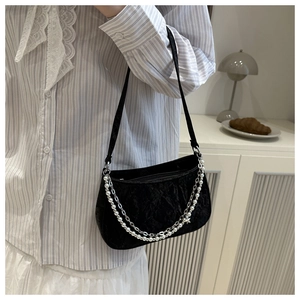 Close-up of velvet crossbody bag with pearl and star metal double chain detail