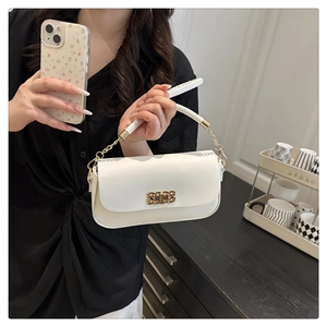 Gros plan d'un sac à bandoulière blanc minimaliste avec boucle dorée et détail de chaîne