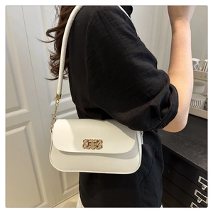 Détail du sac à bandoulière blanc minimaliste avec boucle dorée et sangle en chaîne